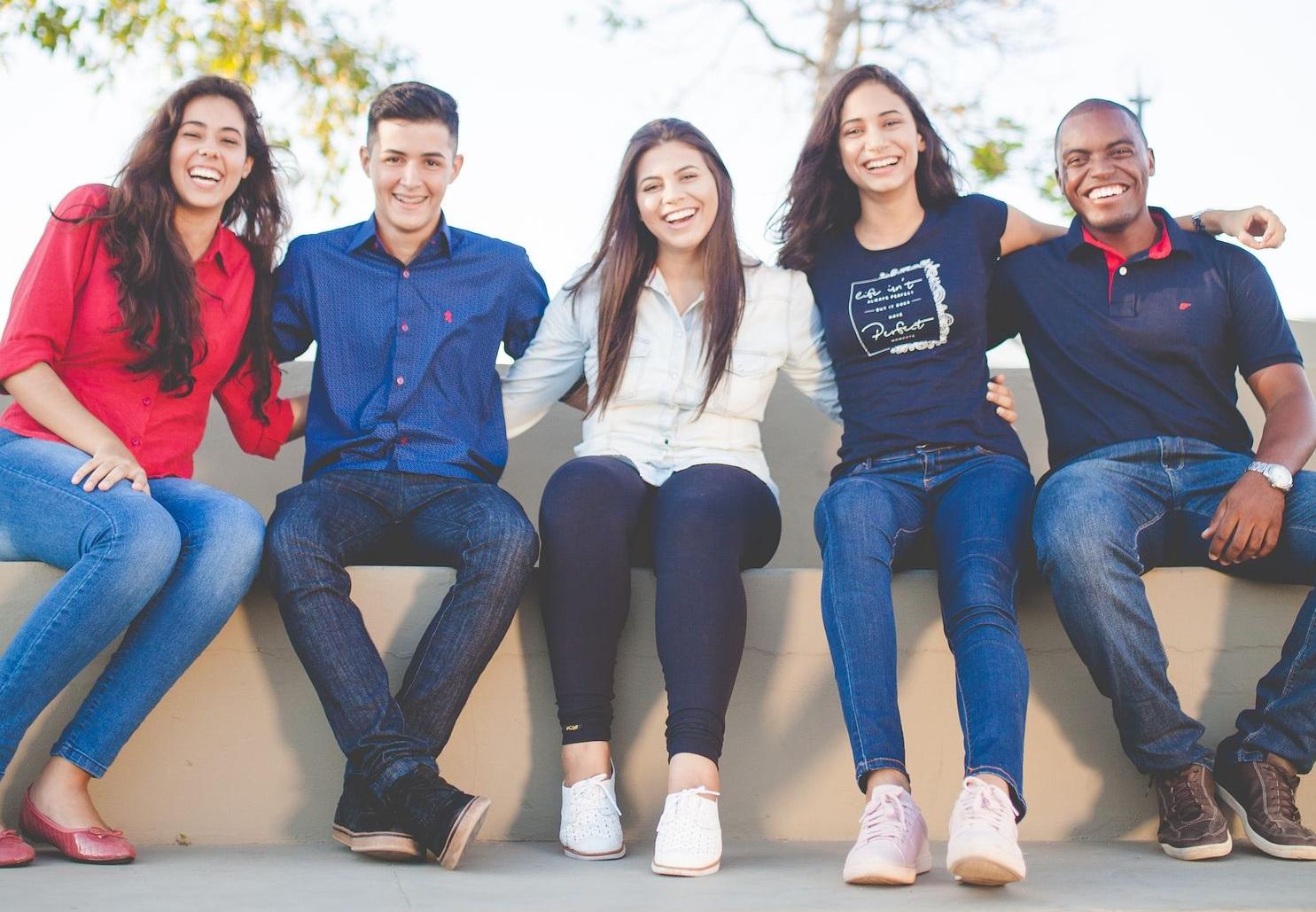 group of people sitting on bench near trees duting daytime